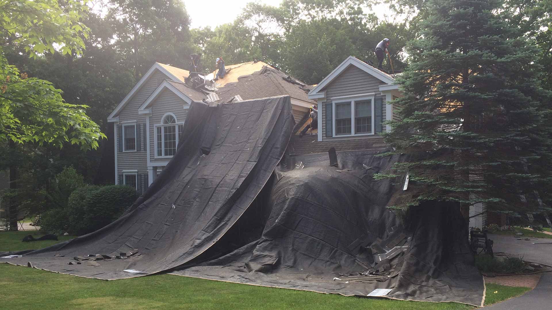 Roofers on tarped house