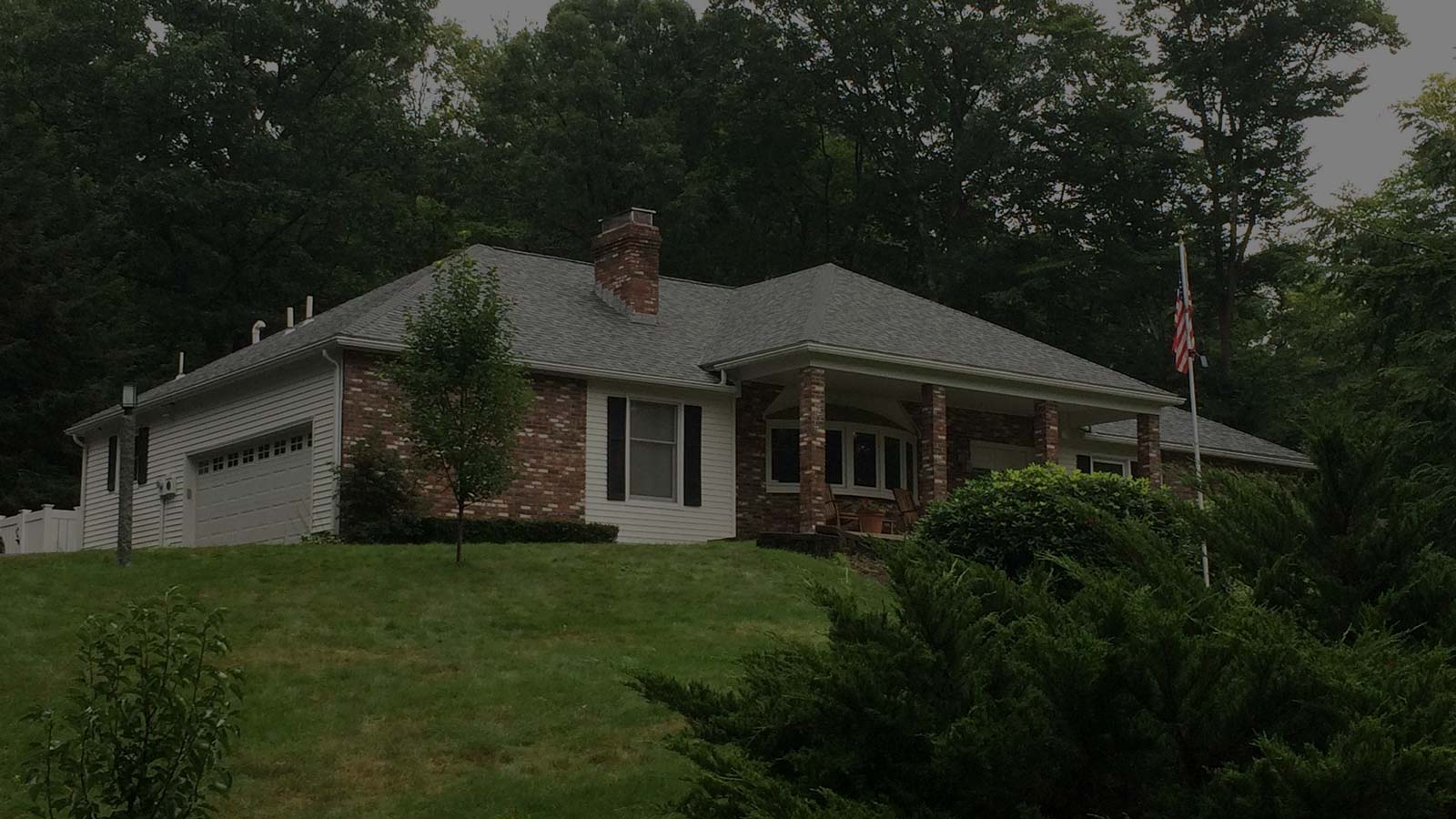 Brick house in NH roof installed by Queen City Roofing