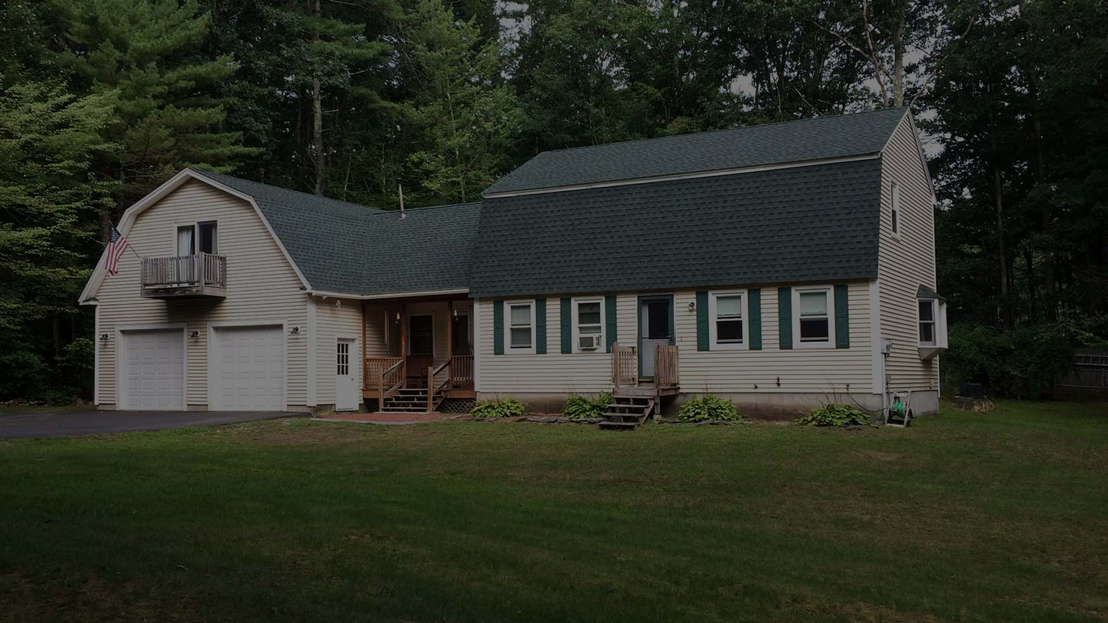 Cream house with green shutters and attached garage in NH
