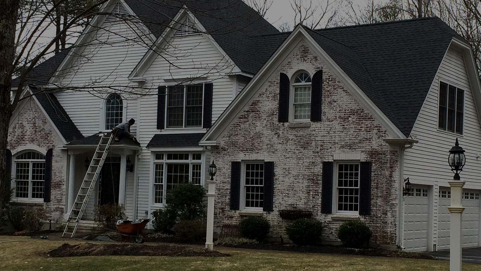 White house with brick face Queen City Roofing Bow, NH